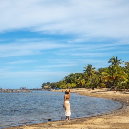 a-young-tourist-on-the-beach-of-sandy-bay-on-roata-2024-12-10-00-34-00-utc
